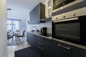 a kitchen with black cabinets and a large microwave at Casa Maja in Brtonigla