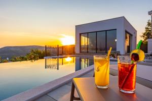 two drinks on a table next to a pool at Villa 72 Crikvenica Riviera in Bribir +112 photos