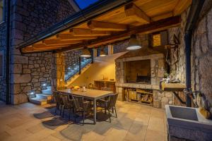 a dining room with a table and a stone fireplace at Villa 72 Crikvenica Riviera in Bribir
