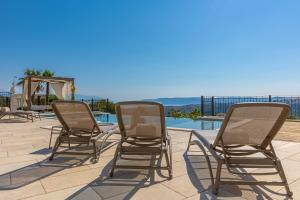 three chairs sitting on a patio next to a pool at Villa 72 Crikvenica Riviera in Bribir