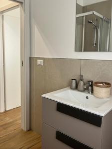 a bathroom with a white sink and a mirror at Ca' dei Venti in Chioggia