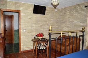 a bedroom with a bed and a table with a chair at Hostal la Encina in El Real de la Jara