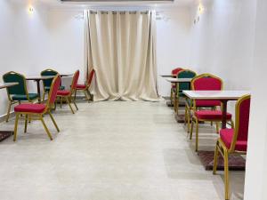 a room with tables and chairs and a curtain at Sacred Crown Suites in Naivasha