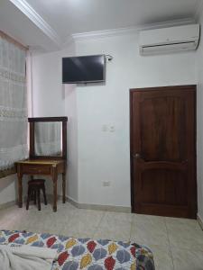 a room with a bed and a tv on the wall at Hotel Victoria in Nueva Loja