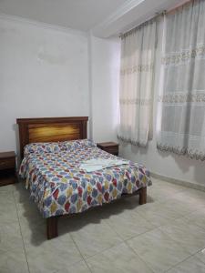 a bedroom with a bed in a room with curtains at Hotel Victoria in Nueva Loja