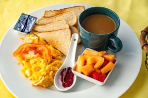 a plate of breakfast food with a cup of coffee at Roxys Inn in Boca Chica