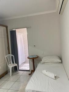 a bedroom with a bed and a chair and a window at Dona Angelina one in Araçatuba