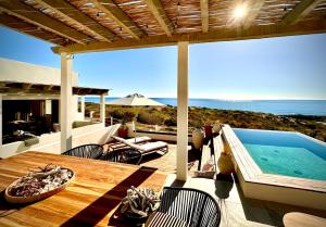 a patio with a pool and a table and chairs at Casa del Mar - Luxury Seaside Villa in Boca de la Vinorama