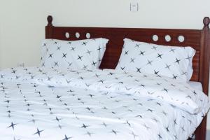a bed with black and white sheets and pillows at Kigali Gem in Kigali