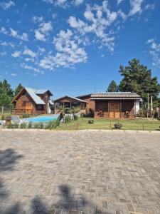 a house with a brick driveway in front of a building at Cabanas das Oliveiras in Torres