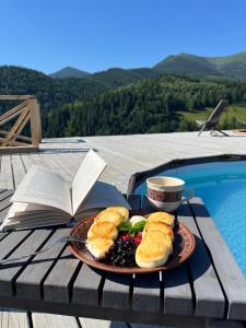 a plate of food on a table next to a book at Familyhata in Dzembronya