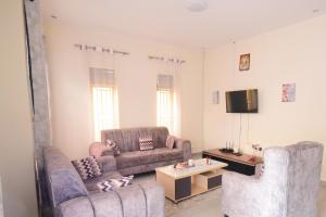 a living room with two couches and a tv at Kigali Gem in Kigali