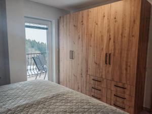 a bedroom with a large wooden cabinet and a bed at Apartma pod Tremi Kralji in Oplotnica