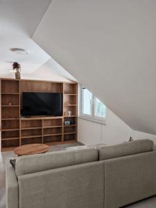 a living room with a couch and a tv at Apartma pod Tremi Kralji in Oplotnica