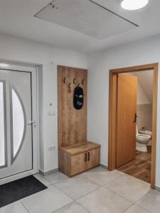 a bathroom with a toilet and a wooden door at Apartma pod Tremi Kralji in Oplotnica +3 photos