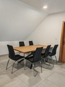 a conference room with a wooden table and chairs at Apartma pod Tremi Kralji in Oplotnica