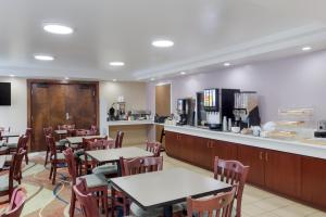 a restaurant with tables and chairs and a counter at All Seasons Inn & Suites Smithfield Providence in Smithfield