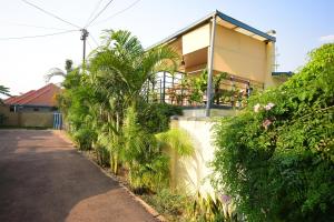 a house with palm trees on the side of a road at Kigali Gem in Kigali