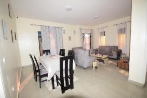 a living room with a table and chairs and a couch at Kigali Gem in Kigali
