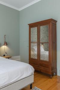 sypialnia z drewnianą szafką i łóżkiem w obiekcie GuestReady - Picaria Living Quarter 3 w Porto