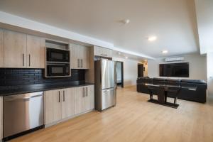 a kitchen with stainless steel appliances and wooden cabinets at Complexe la Falaise in Rivière-du-Loup