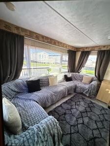 a bedroom with two beds in front of a window at Sandylands caravan park in Stevenston +50 photos