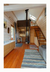 a living room with a staircase in a tiny house at Brīvdienu Māja Martz in Engure