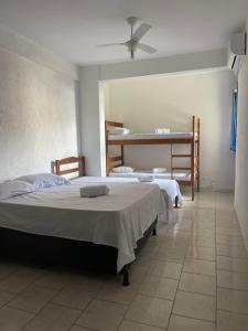 a bedroom with two beds and a bunk bed at Hotel Costa Rio in Rio das Ostras +20 photos