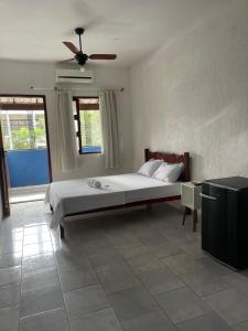 a bedroom with a bed and a ceiling fan at Hotel Costa Rio in Rio das Ostras