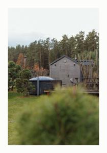 a couple of buildings in a field with trees at Brīvdienu Māja Martz in Engure