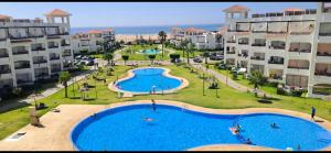an aerial view of an apartment complex with a large swimming pool at Beachfront Apartment in Assilah, Private Solarium, 4 Pools, Secure Residence, WiFi, Parking in Asilah