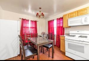 a kitchen with a table and chairs and a stove at Large 3-Bedrooms/2-Bath Apt, One Block to Train in Brooklyn