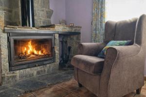 a living room with two chairs and a fireplace at ELS OCELLS Apartaments i Cases Rurals in Camprodon +53 photos