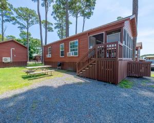 a house with a deck and a picnic table at Sun Outdoors Frontier Town in Berlin