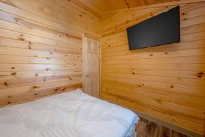 a bedroom with a tv on a wooden wall at Sun Outdoors Frontier Town in Berlin +11 photos