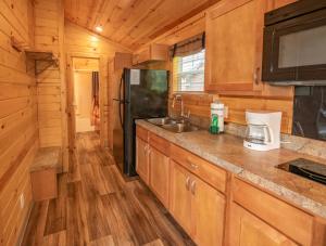 a kitchen with a sink and a black refrigerator at Sun Outdoors Frontier Town in Berlin