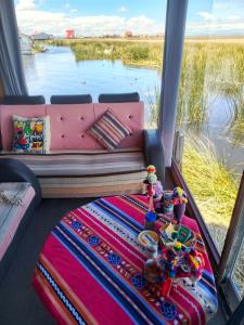 a couch in a room with a view of the water at INTI UTA titicaca in Puno