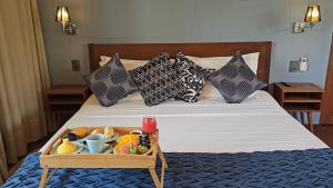 a tray of food on a bed with pillows at Vila das Águas in Atins