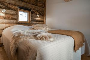 a bedroom with a white bed with a wooden wall at Rinneköngäs - Ruka-Pyhä 2x SKIPASS included - Free Skibuss Doorstep - Renovated in Ruka +26 photos