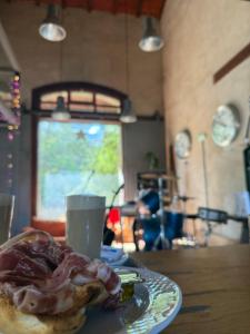 a plate of food with meat on a table with a drink at Albergue & Cafetería Vía de la Plata Hervás in Hervás