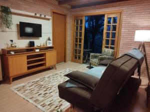a living room with a chair and a television at Cabana liberdade 2 in Rio dos Cedros