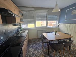 a kitchen with a table and a table and chairs at Apartman Lipik in Lipik