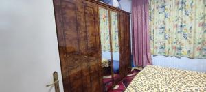 a bedroom with a wooden cabinet next to a bed at Wohnung in der Ruhr Witten in Witten