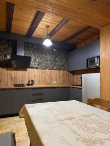 a kitchen with a table and a white refrigerator at Гуцульська оселя in Yaremche