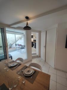 a dining room with a wooden table and chairs at Le Liseo - Terrasse, véranda au cœur du centre ville in Niort +4 photos