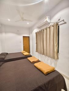 two beds in a room with a curtain at Laxmi Residency in Akalkot