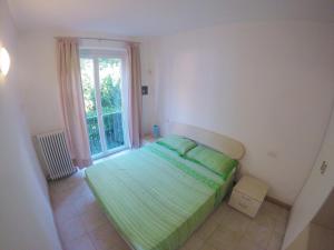 um quarto com uma cama verde e uma janela em Residence White Beach em Lierna