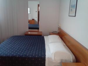 a small bedroom with a bed with a blue mattress at Hotel Niki in Tribiano