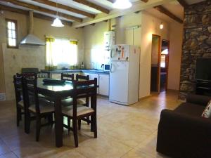 a kitchen and dining room with a table and a white refrigerator at Apart Hotel La Bodega in San Rafael