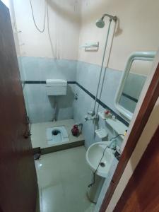 a small bathroom with a toilet and a sink at Second Home Hotel in Multan